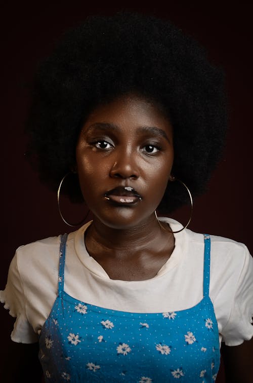 A woman with an afro wearing a blue dress