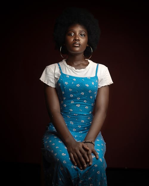 A woman in a blue dress sitting on a chair