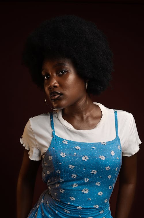 A woman with an afro wearing a blue dress