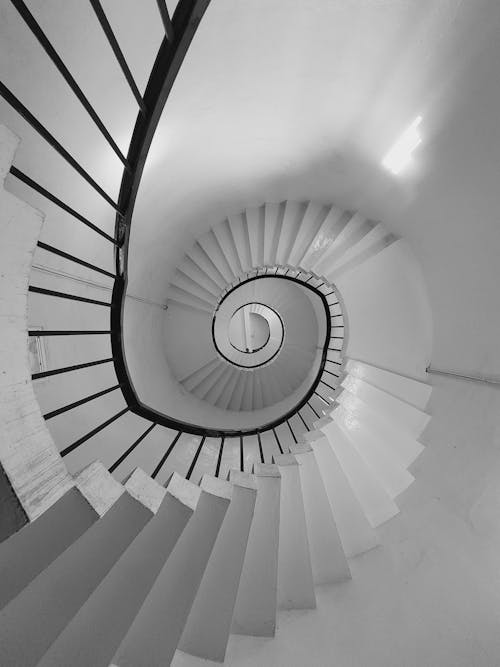A black and white photo of a spiral staircase