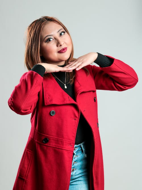 A woman in a red coat posing for a photo