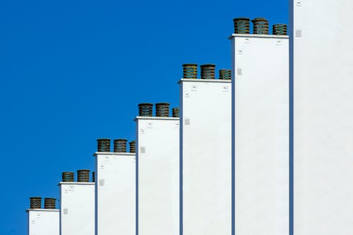A row of white chimneys against a blue sky
