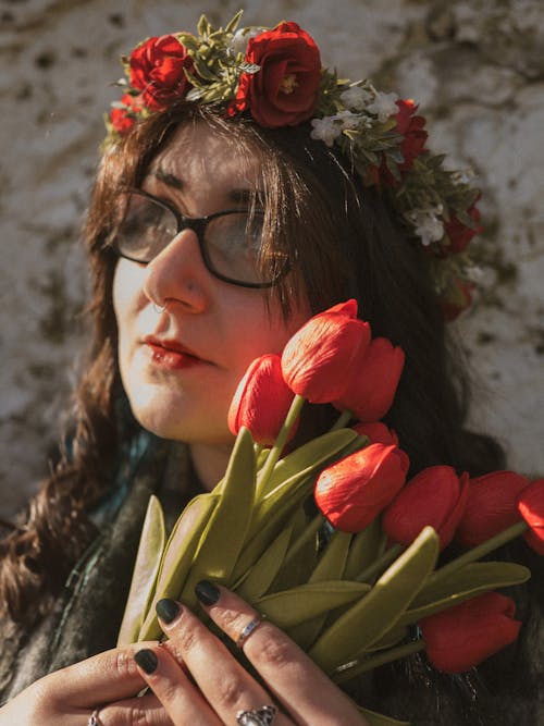 A woman with glasses and flowers in her hair