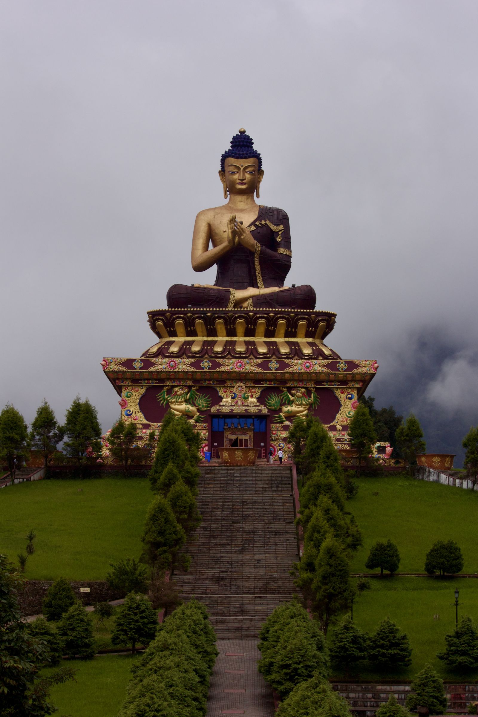 The great seated Buddha at Tathagata Tsal in Ravangla, above its stone steps and lawns with mist on the hills behind