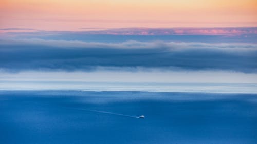 Clouds over Sea with Sailing Ship at Sunset