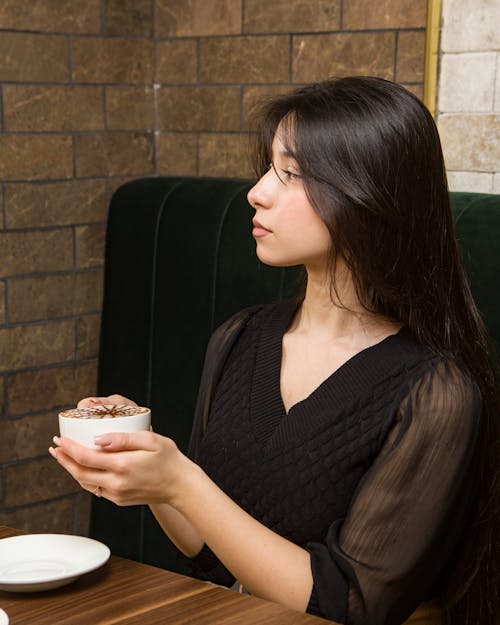 Young Woman Drinking Hot Chocolate in a Cafe