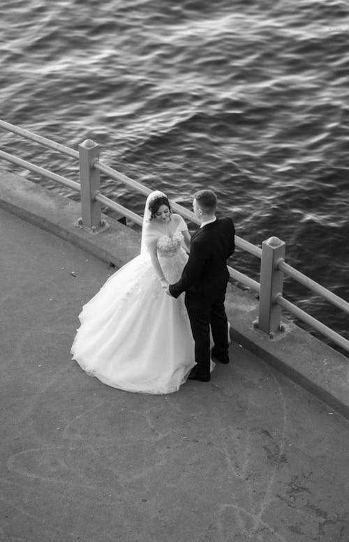 Newlyweds Holding Hands on Sea Shore in Black and White