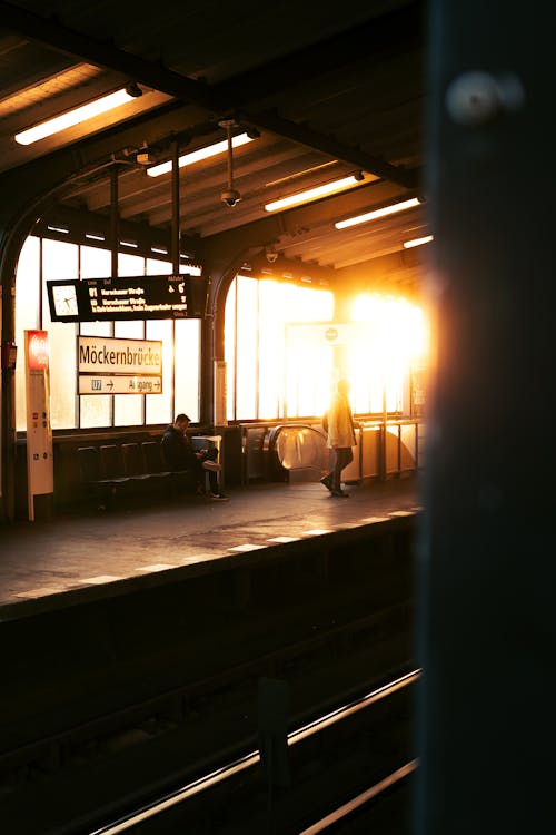 A train station with a sun setting in the background