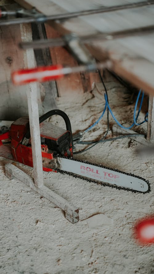 Chainsaw on the Floor Covered with Sawdust