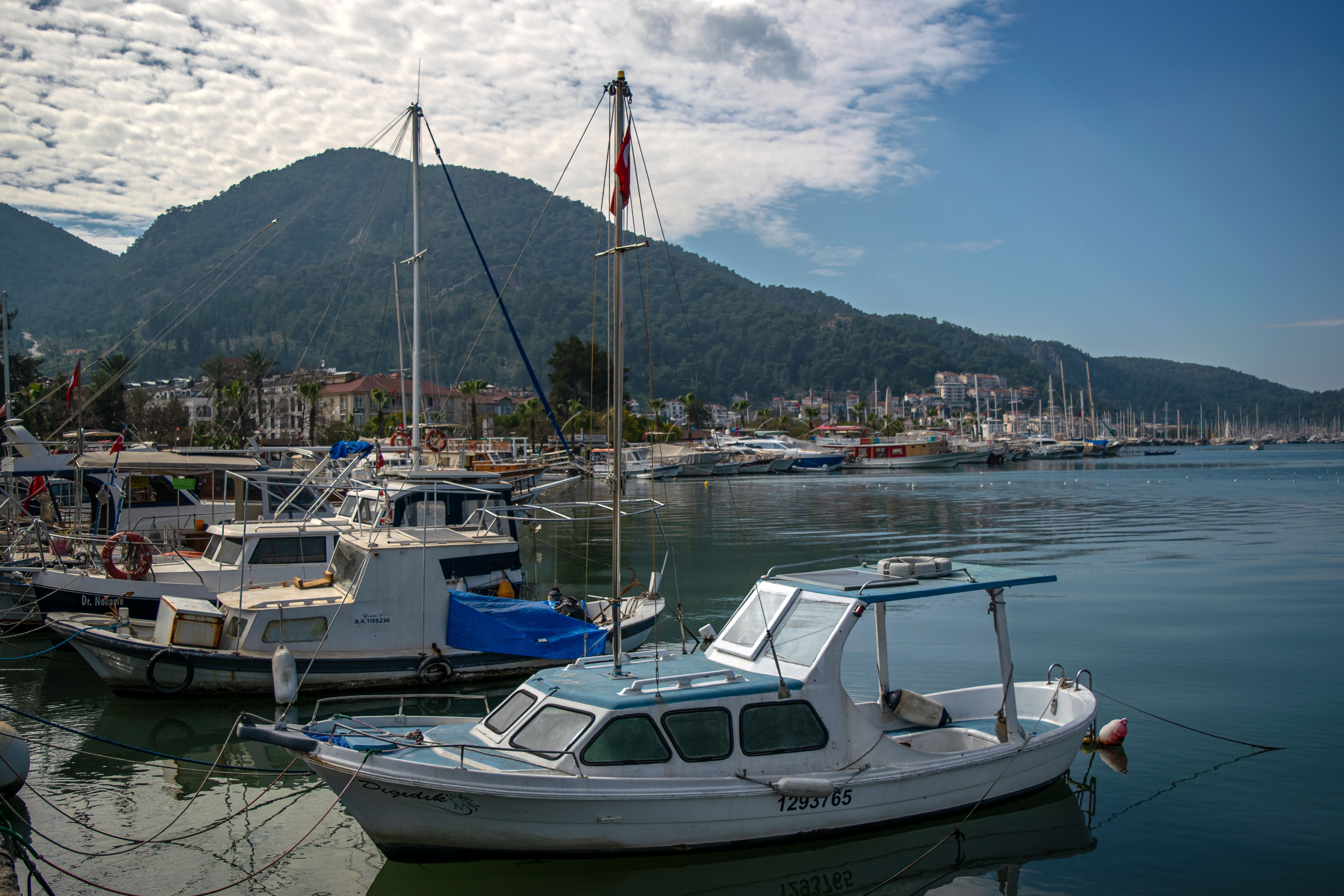 Explore the beautiful coastal town of Fethiye, Türkiye, with its marina and picturesque hills.