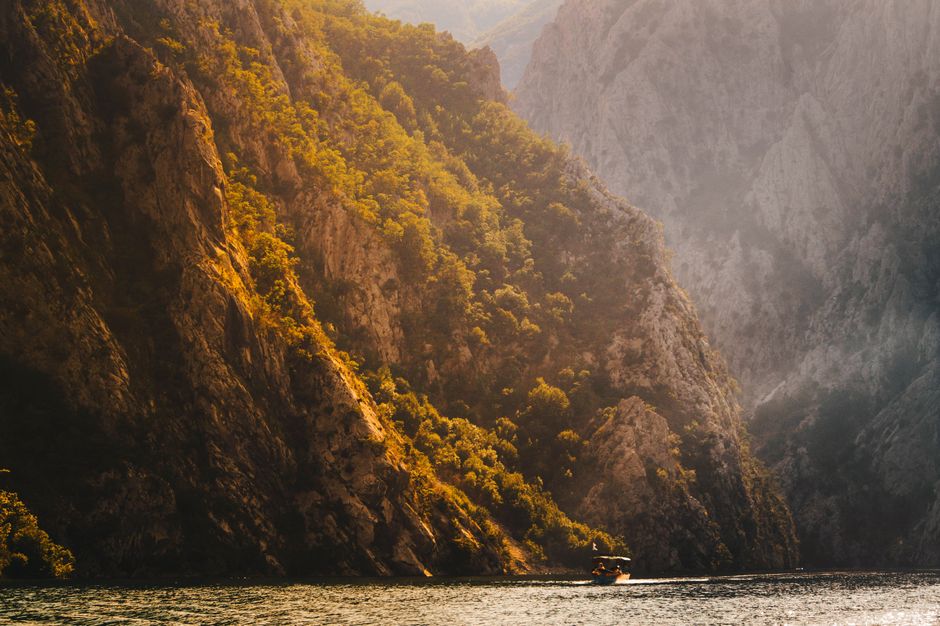 A serene boat navigating through the dramatic canyon landscape of Kukës, Albania.