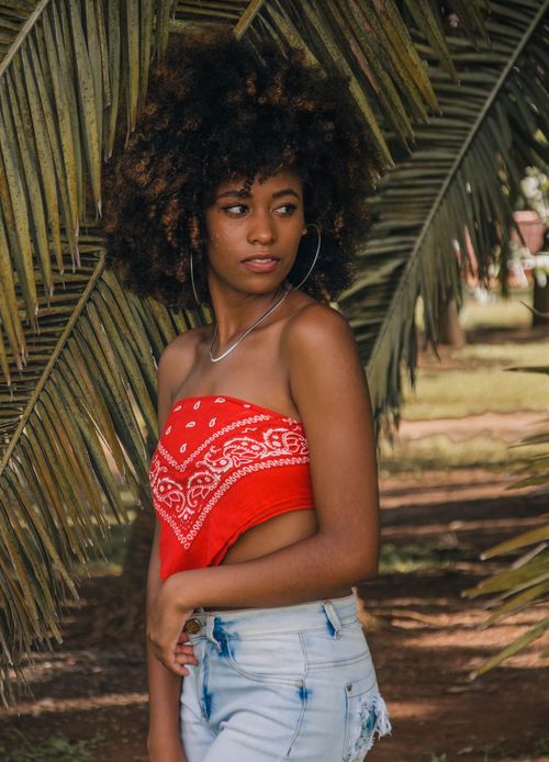 Free Beautiful portrait of a woman with afro hair in a tropical outdoor setting. Stock Photo