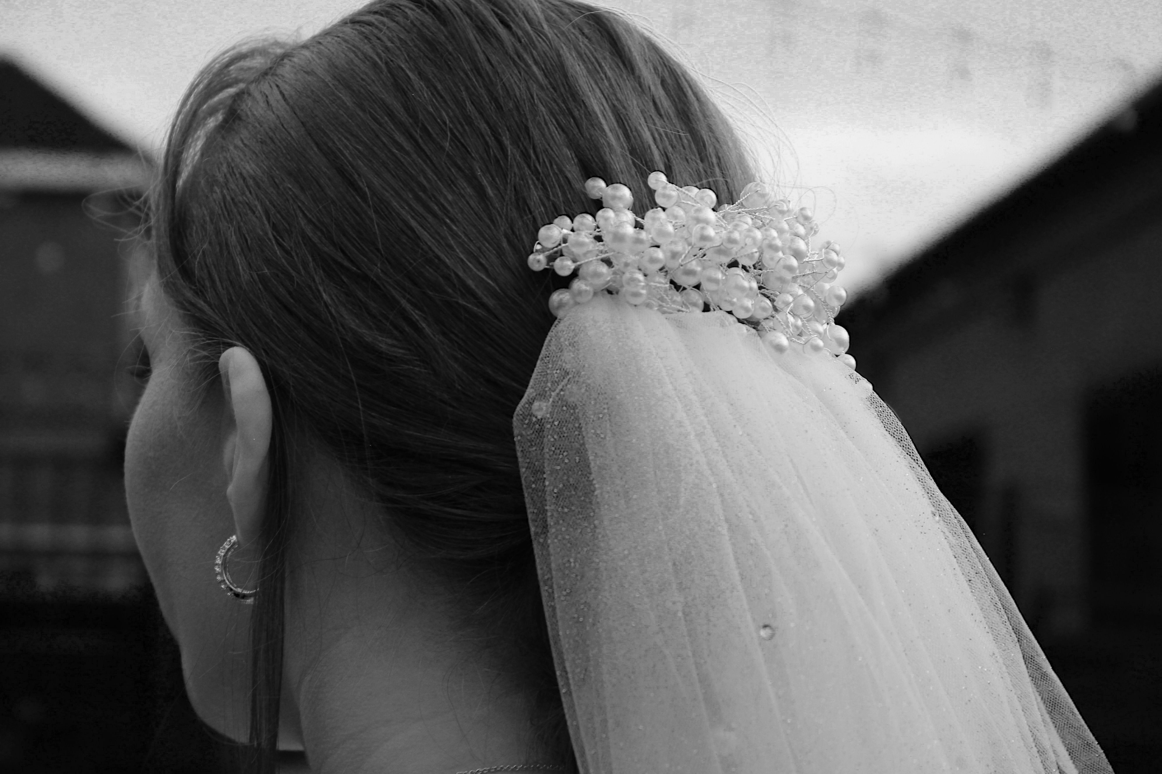Back view of a bride wearing a long veil secured into her wedding hairstyle