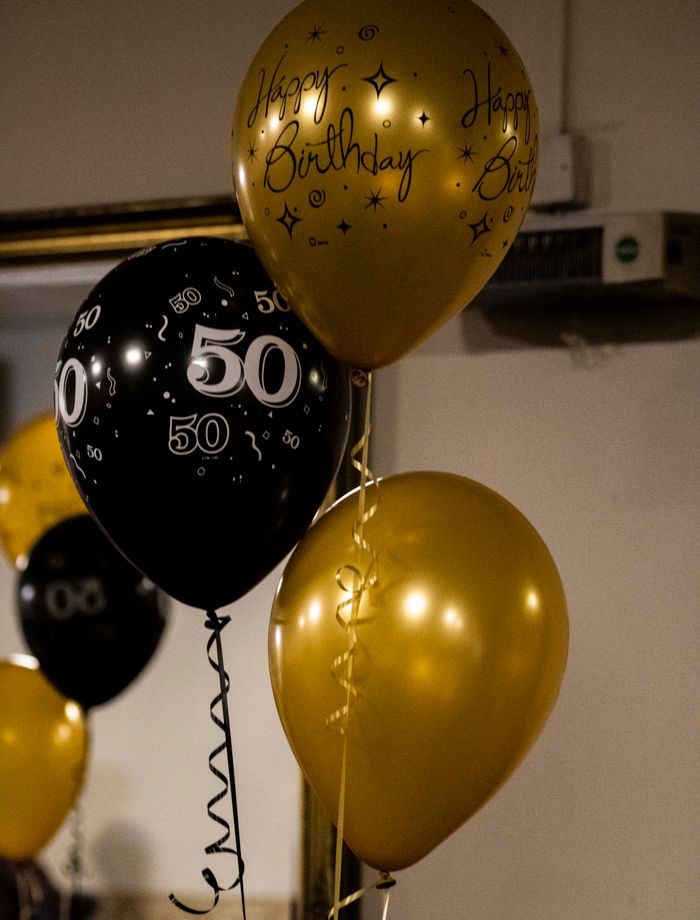 Black and gold milestone birthday balloon styling