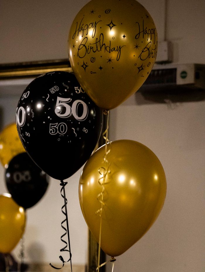 Black and gold milestone birthday balloons