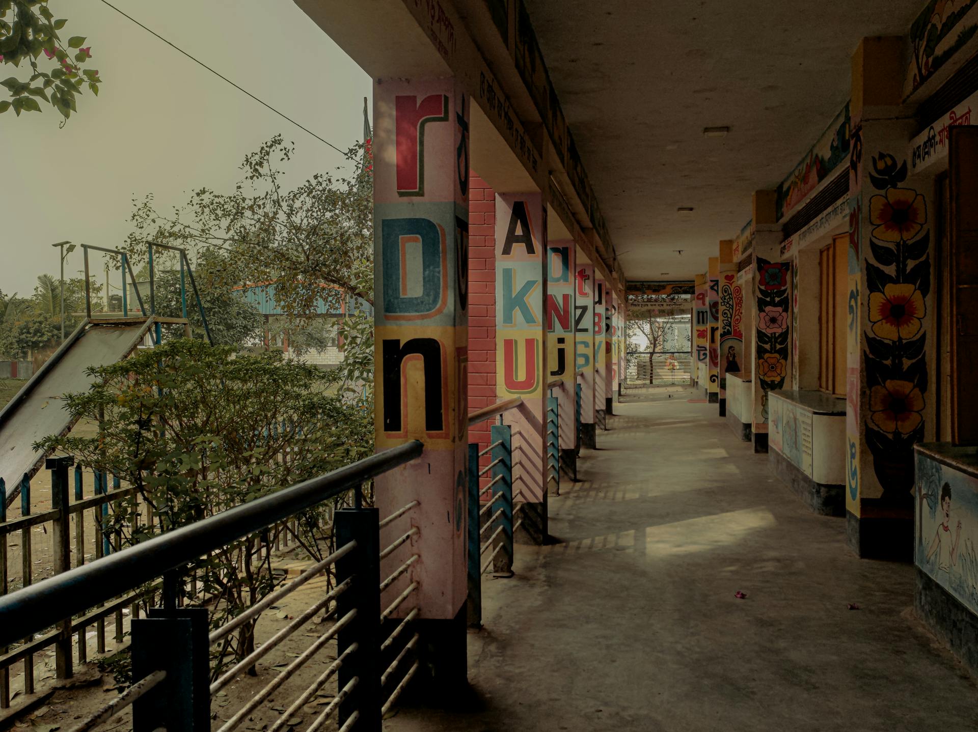 Vibrant corridor with artistic pillars in a Bangladeshi schoolyard.