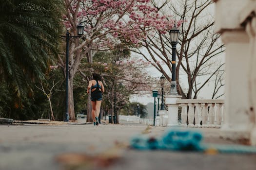 一位女士在风景如画的公园里慢跑，公园里满是盛开的春树和老式街灯