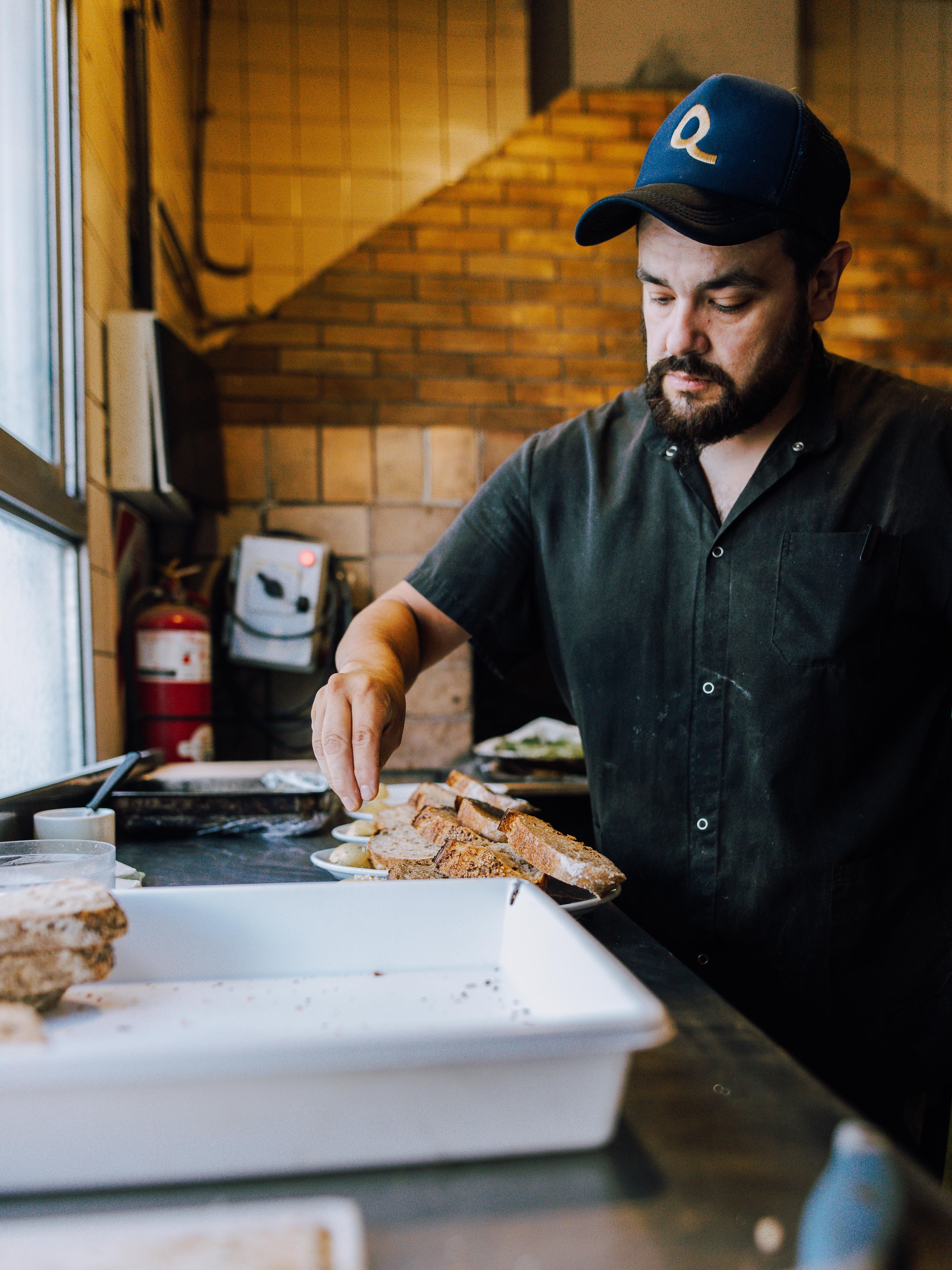 Male chef in a Buenos Aires kitchen preparing artisan bread with focus and precision.