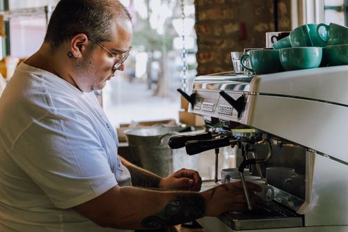 Free Barista using espresso machine in a Buenos Aires café, focused on crafting a coffee. Stock Photo
