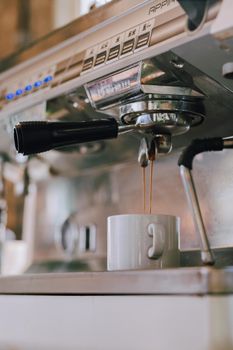 Close-up of an espresso machine brewing into a white cup, located in Buenos Aires cafe.