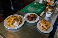 Top view of tasty Argentine meal with fries, sandwich, and meatball plate on a kitchen counter.