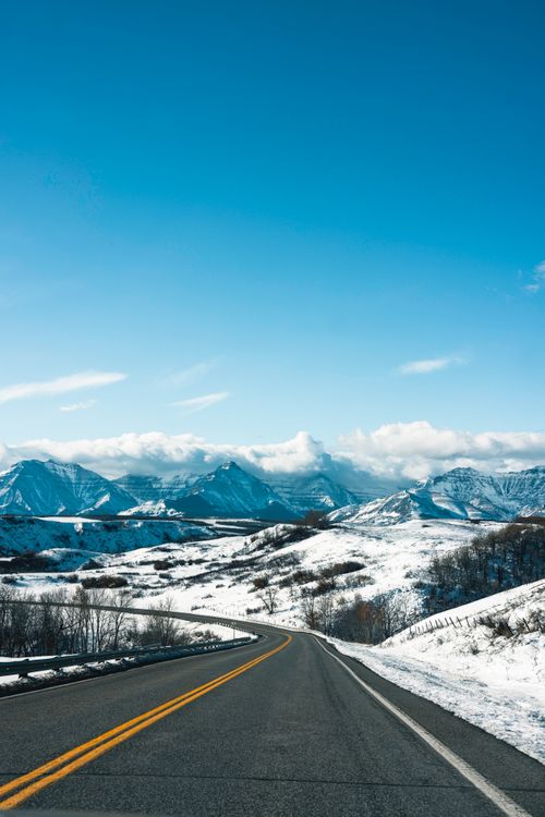 Free Majestic mountain view along a snowy highway in Waterton Park, Canada, during winter. Stock Photo