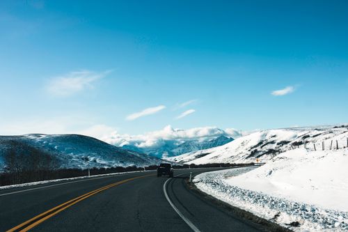 Free Car driving through snowy Waterton Park, Alberta, with stunning mountain views. Stock Photo