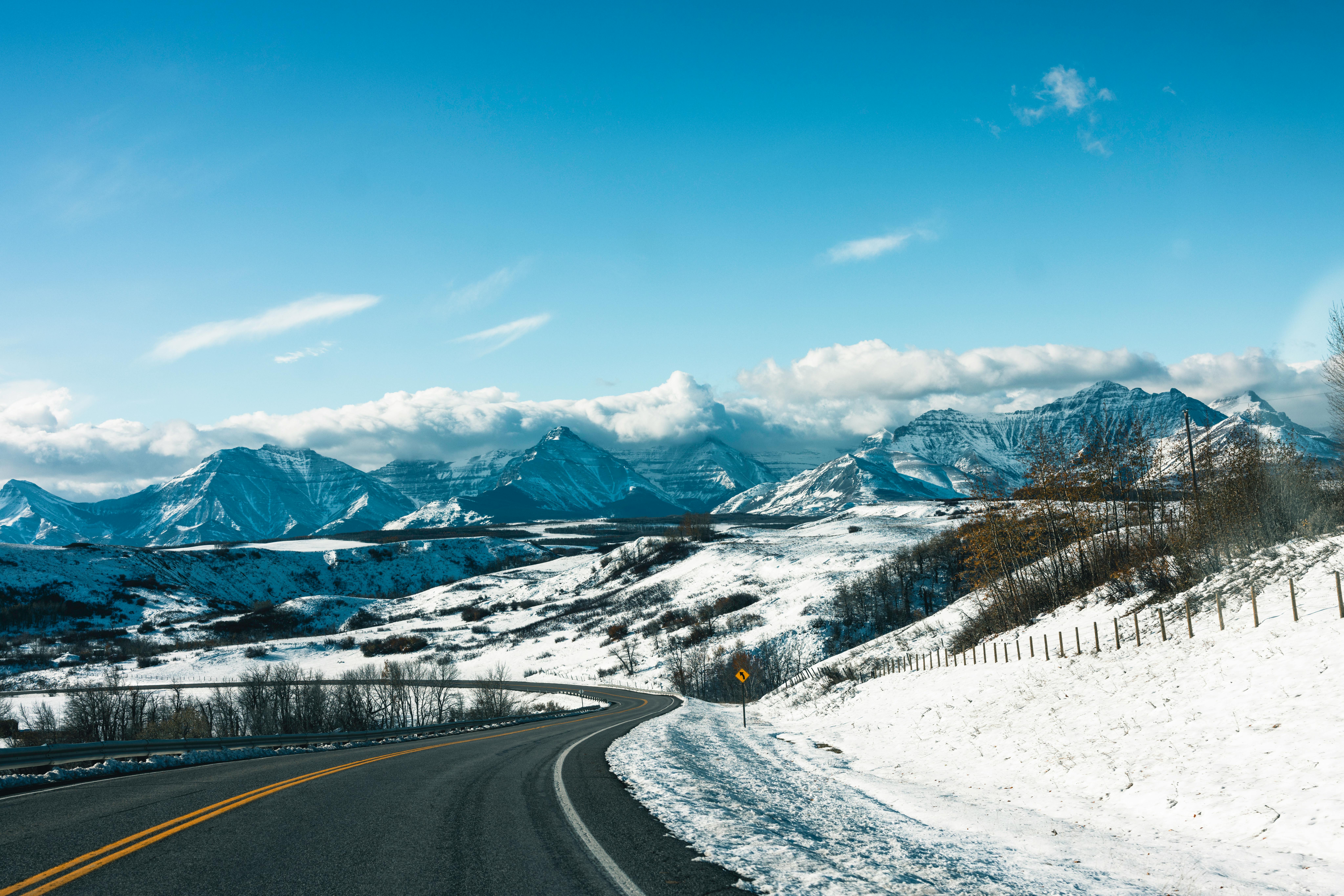 Scenic winter road winding through mountains in Waterton Park, Alberta, Canada.