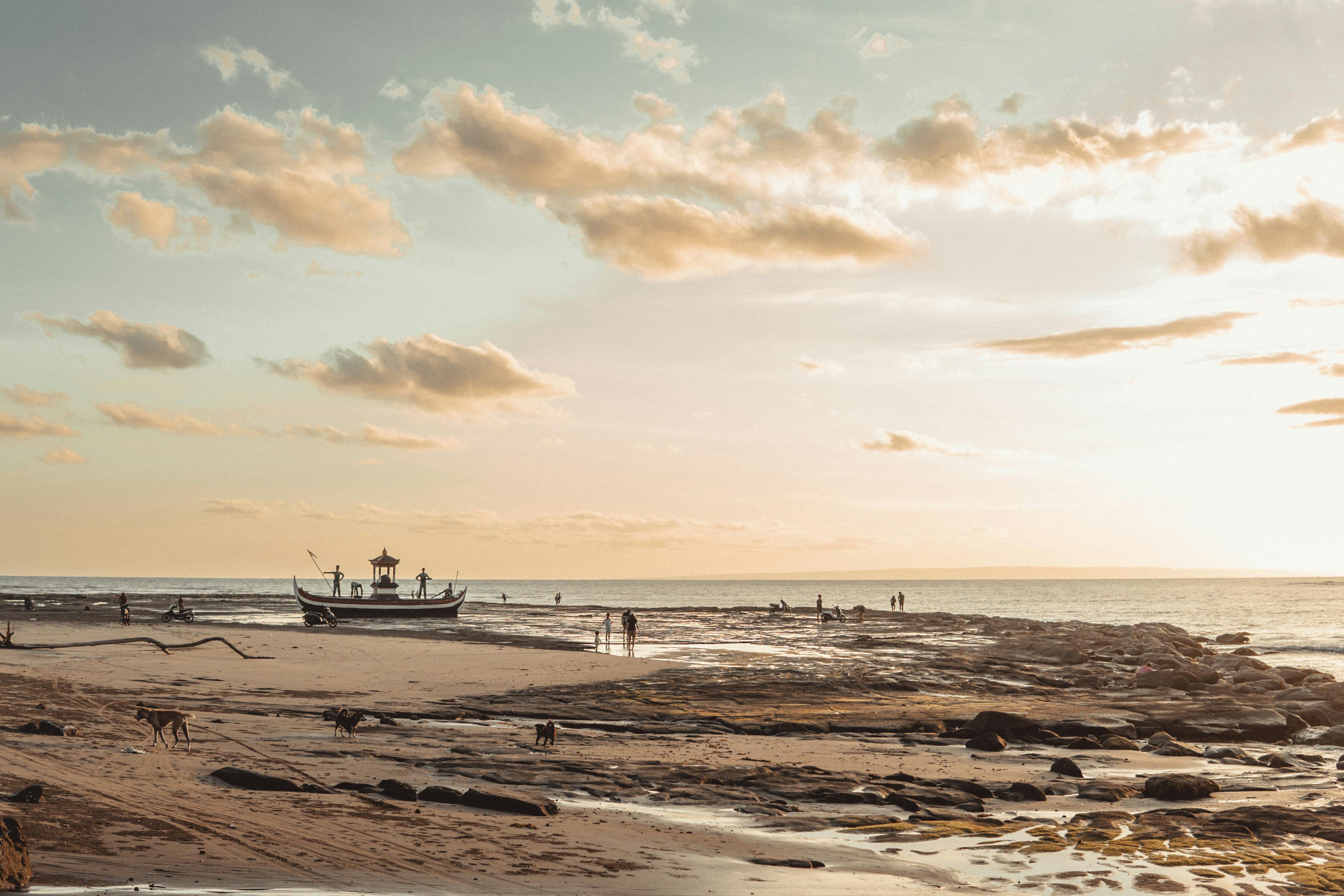 Peaceful beach in Pulukan, Bali with a fishing boat at sunrise. Ideal for travel and nature themes.