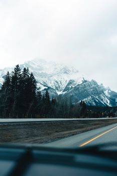 A picturesque drive through snowy mountains in Banff National Park, capturing winter's serene beauty.