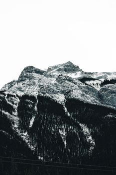 Stunning snow-covered rocky mountain peak in Banff, AB, Canada, showcasing nature's grandeur.