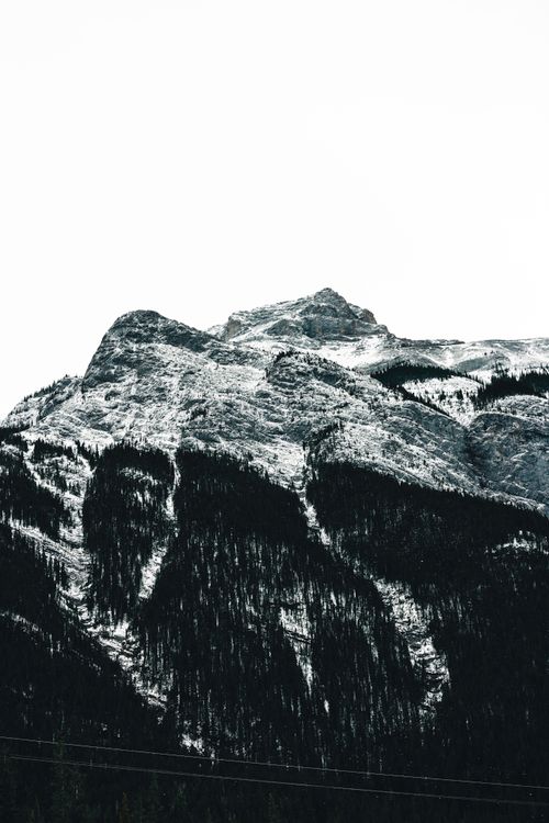 Free Stunning snow-covered rocky mountain peak in Banff, AB, Canada, showcasing nature's grandeur. Stock Photo
