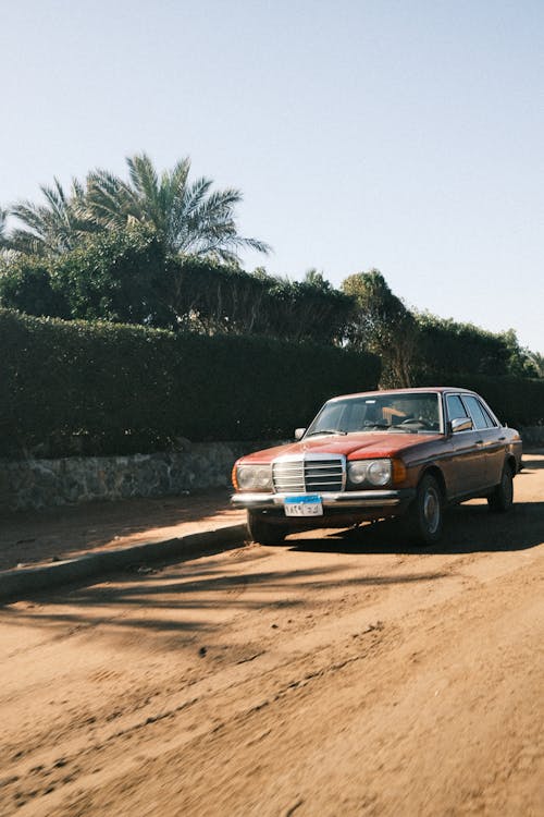 A car driving down a dirt road in the desert