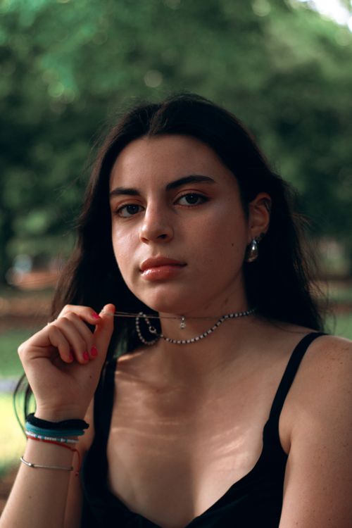 Free Young woman posing outdoors with natural sunlight in São Paulo park. Stock Photo