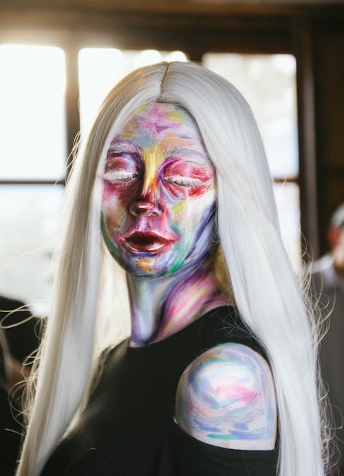 A woman with white hair and colorful makeup
