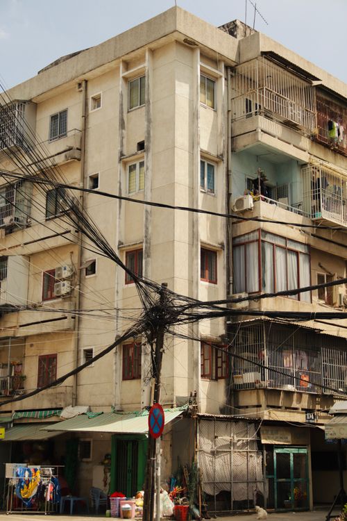 Free Aged apartment building with exposed utility wires in an urban setting. Stock Photo