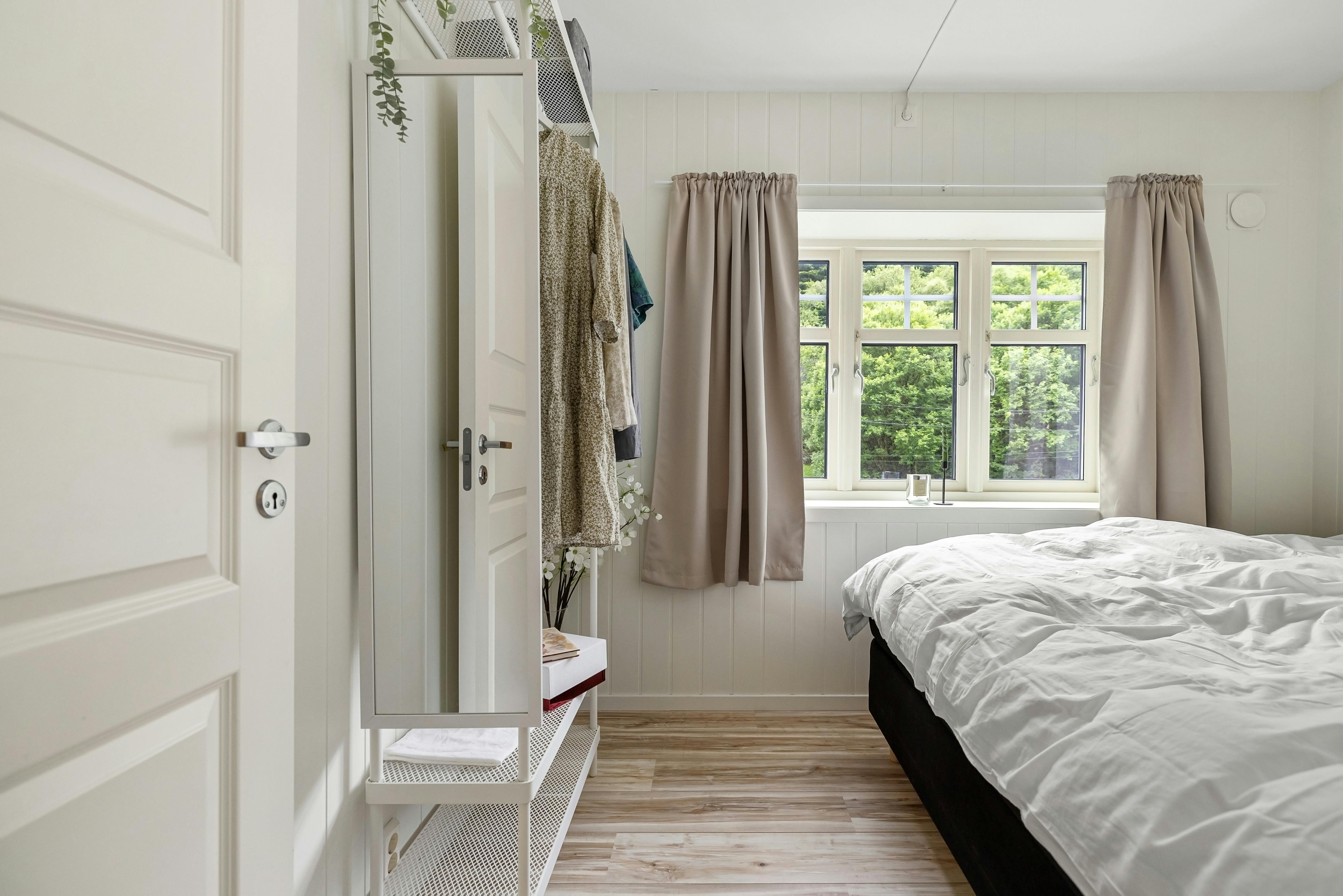 A serene and minimalist bedroom with natural light, featuring a cozy bed and chic decor. Perfect for modern living.