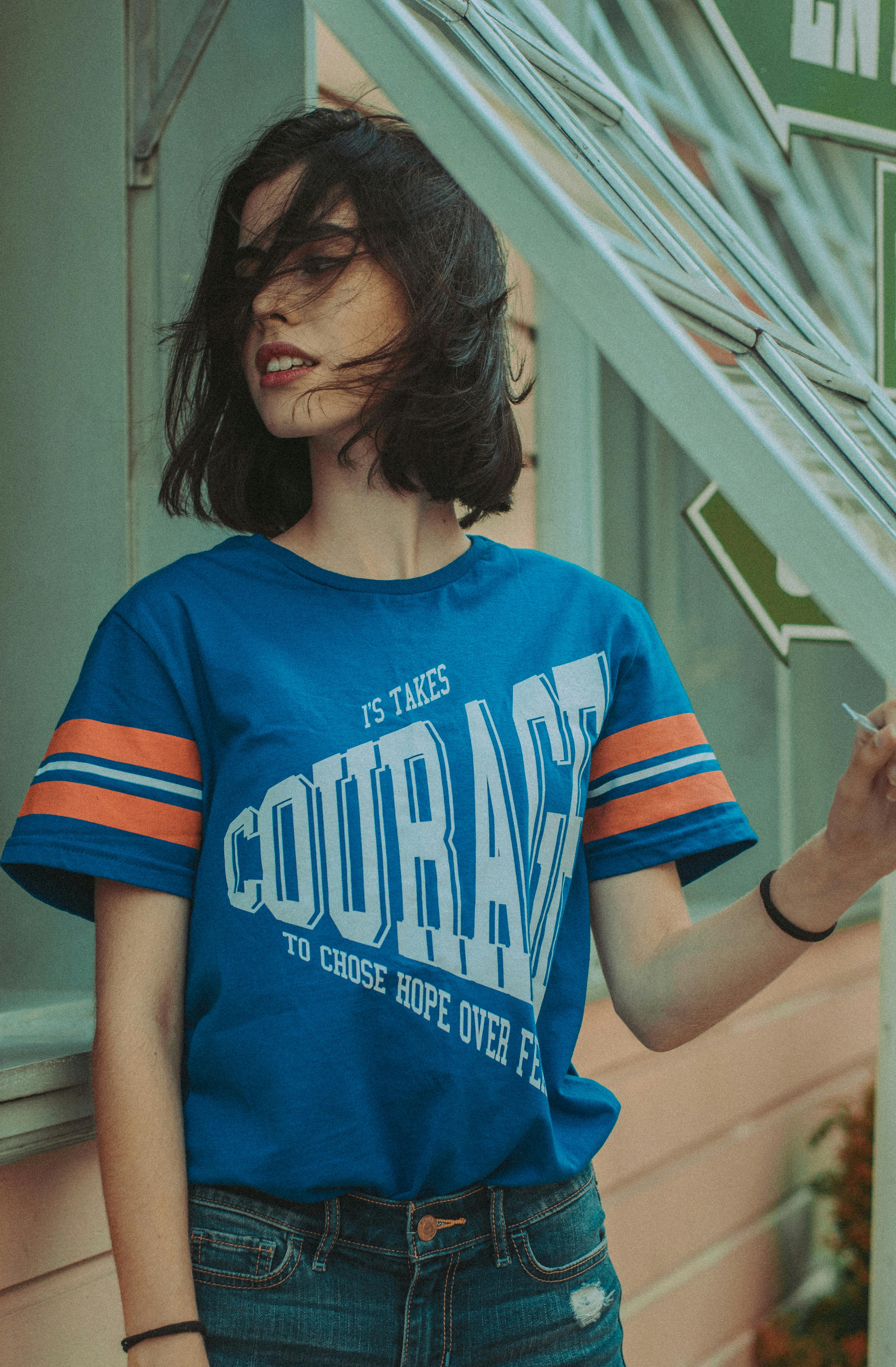 一位留着黑色短发的时尚女性，在户外以休闲别致的风格摆着姿势