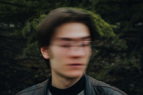A blurry image of a man with glasses