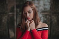 一位身穿红色连衣裙的时尚女子在室内优雅地摆姿势，肖像安详