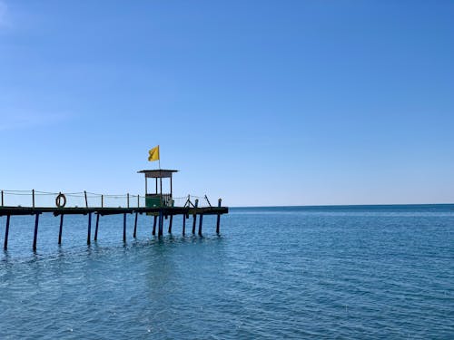 Lifeguard Tower on Pier on Sea Shore under Clear Sky