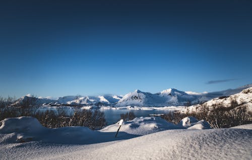 A snowy landscape with mountains and snow covered