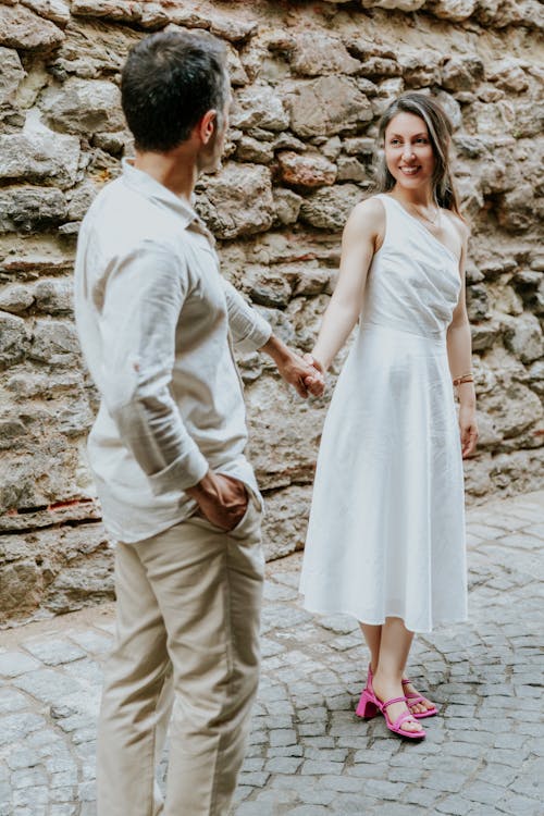 Elegant Couple Standing on a Sidewalk and Holding Hands