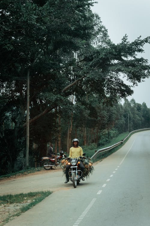A man on a motorcycle is riding down a road