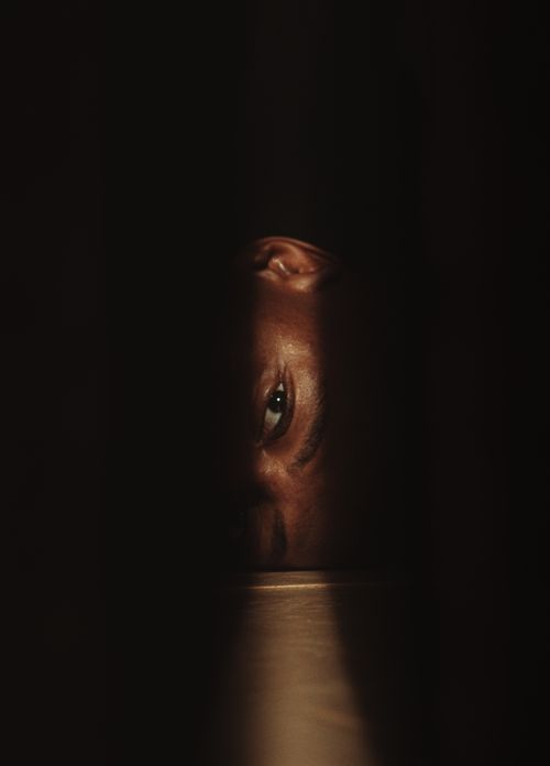 Free A mysterious eye peeks through darkness, creating an intriguing and suspenseful atmosphere. Stock Photo