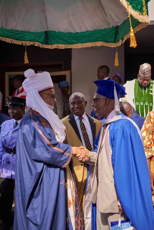 Free A university graduation ceremony featuring a traditional handshake between an elder and a graduate. Stock Photo