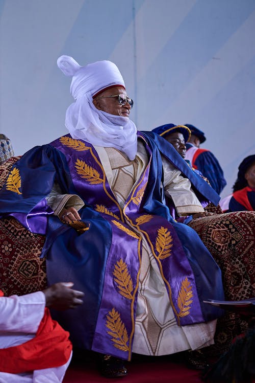 A Man in a Traditional Gown and Turban Sitting at a Ceremony 
