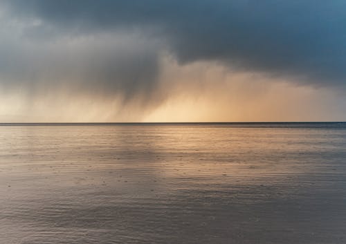 View of a Sunset Sky with Dark Clouds over a Sea