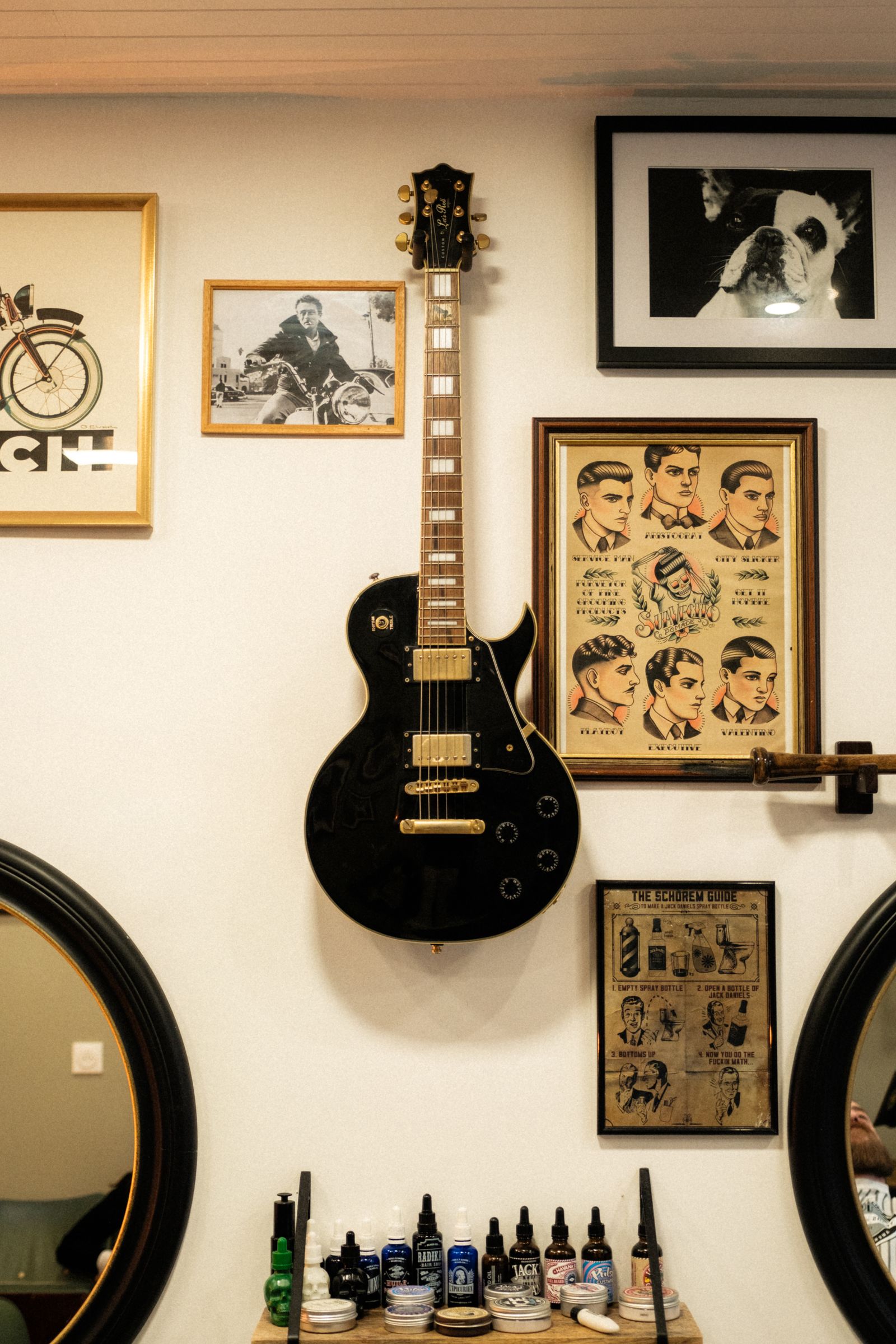 Framed vintage prints and a guitar on the studio wall