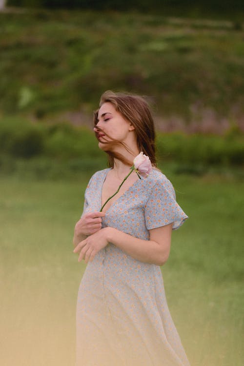 A woman in a dress is standing in a field